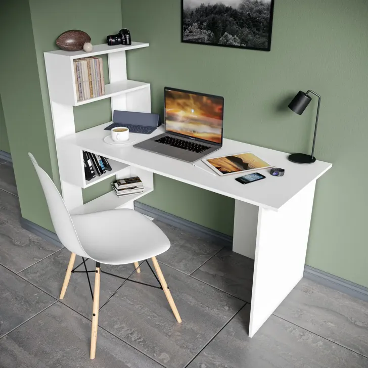 Modern white small corner desk with an integrated multi-tier bookshelf, featuring a laptop, tablet, and a white minimalist chair against a sage green wall.
