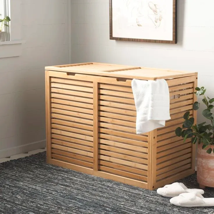 A natural bamboo double laundry hamper with a slatted front design and a hinged lid, featuring two separate compartments.