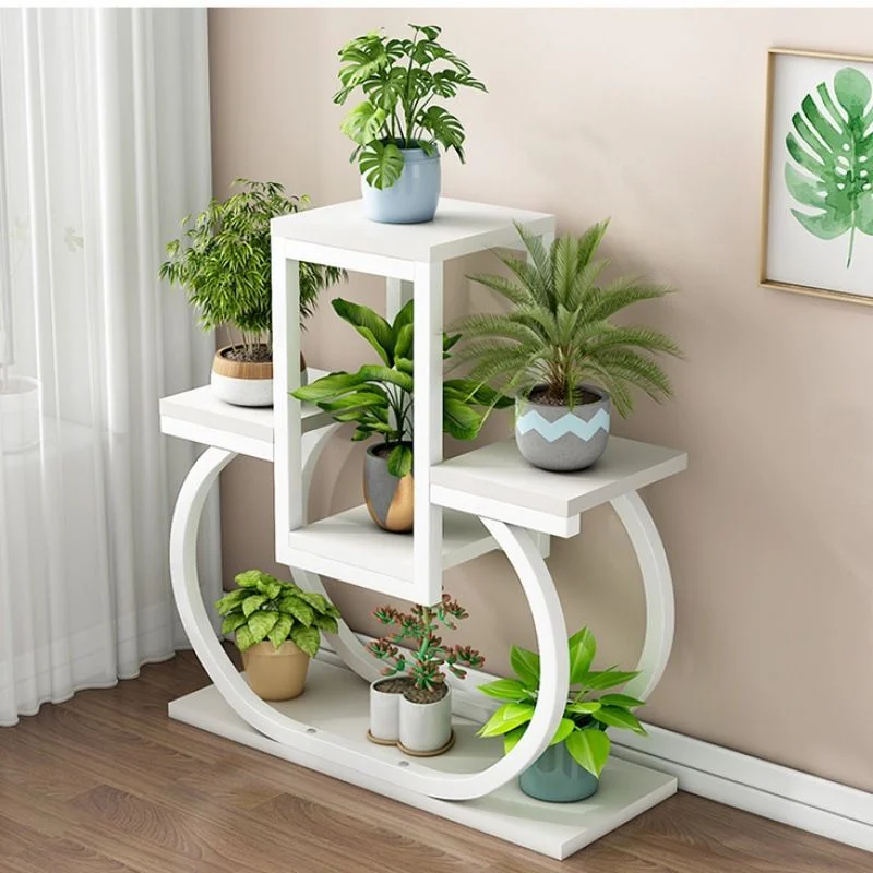 Minimalist white geometric plant shelf with small green houseplants against a beige wall.