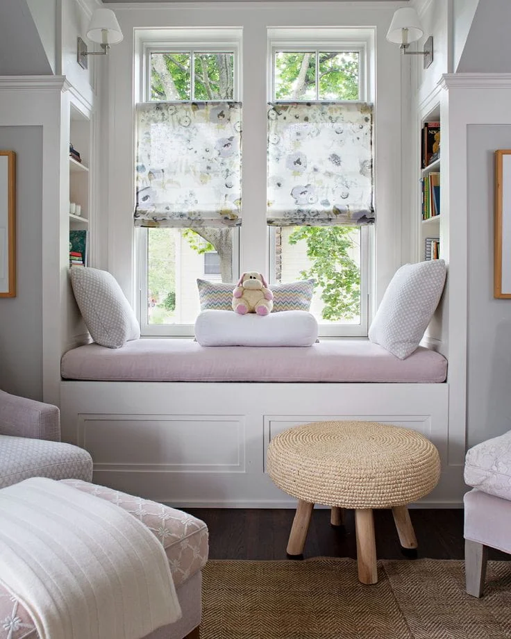 This delightful and airy window seat is the perfect blend of playful charm and smart, space-saving design. Set between two bright windows, this cozy alcove is tailored for relaxation, making it an ideal addition to a nursery, child's bedroom, or a light-hearted reading corner.

Soft pastel tones, whimsical patterns, and natural textures work together to create an inviting, comforting retreat that feels both fresh and timeless.