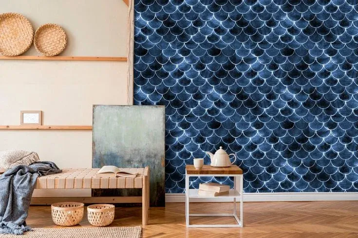 A cozy home entryway featuring removable watercolor wall decor in a deep blue scallop pattern, paired with a woven bench, natural wicker baskets, and a minimalist side table.